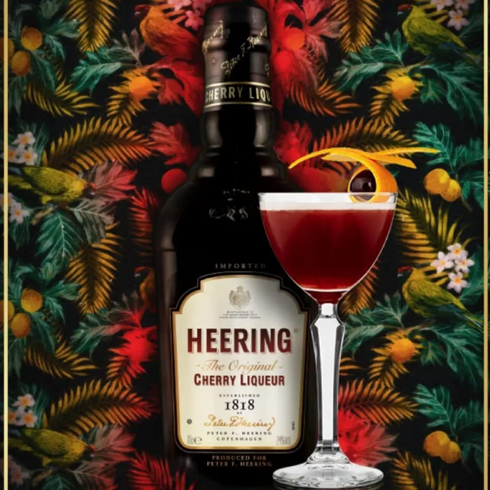 Bottle Of Heering Cherry Liqueur  With Colourful Botanical Themed Background