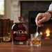 Bottle of Papa's Pilar Sherry Finish Rum with rum over ice
