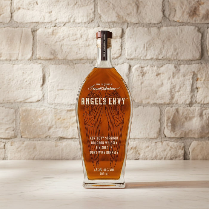 Bottle of Angels Envy bourbon whiskey against a stone wall background