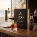 Angostura 200 Year Anniversary Bitters bottle and packaging on a wooden surface with a glass of bitters.