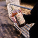 Person holding a bottle of Bruichladdich Old Skool whisky outdoors.
