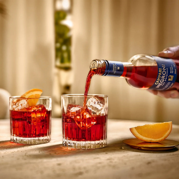 Pouring Campari Negroni Cocktail Into Two Glasses