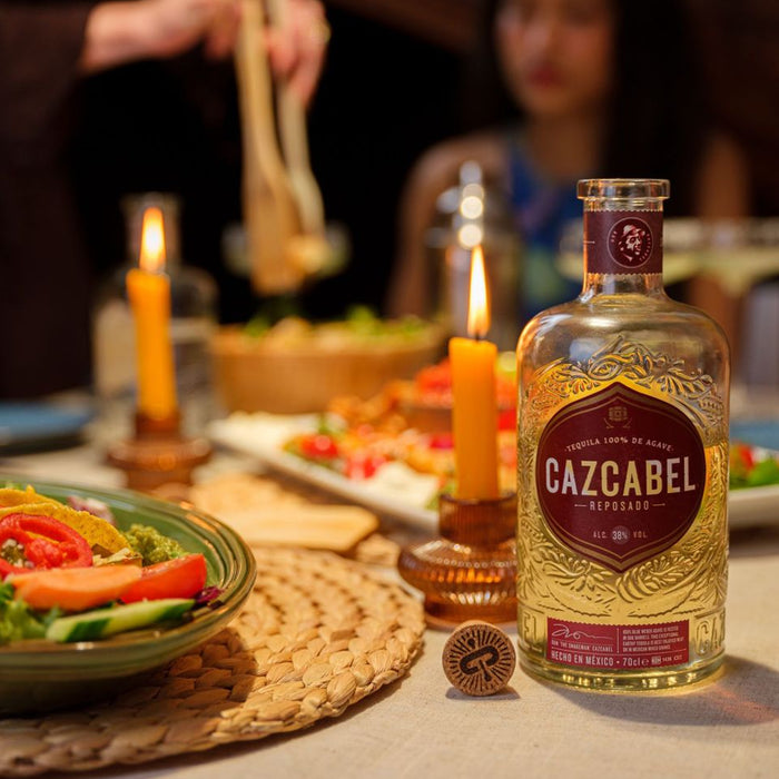 Family eating tacos and a bottle of Cazcabel Reposado 