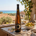 Asti bottle with glasses and fruit on a wooden table with a scenic background