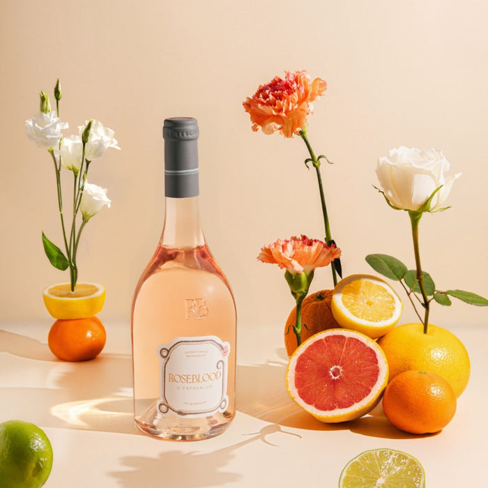 Bottle of Roselock rosé wine with fruits and flowers on a beige background