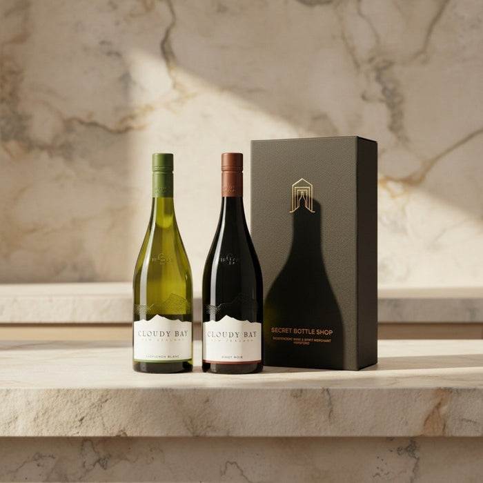 Two bottles of Cloudy Bay wine and a black gift box on a marble surface.