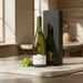 Wine bottle with grapes and packaging on a wooden surface