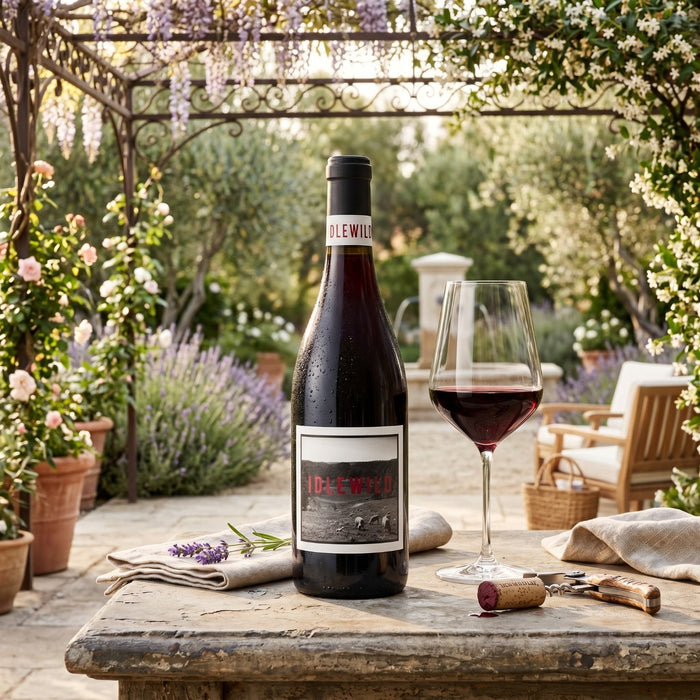 Idlewild Lost Hills Ranch Dolcetto in a courtyard garden with a glass of red