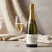 Bottle of 'La Vigne aux Alouettes' wine with a glass of champagne on a neutral background