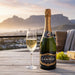 Bottle of Laborie champagne with a glass on a wooden table with a scenic background