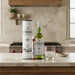 Laphroaig whisky bottles and packaging on a kitchen counter with a glass of water.