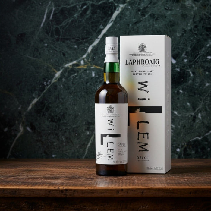 Bottle and box of Laphroaig whisky on a wooden surface with a dark marble background