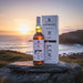 Bottle and box of Laphroaig whisky with a scenic background