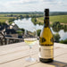 Le Domaine d'Henri Chablis Saint Pierre with a glass of wine over looking a river.