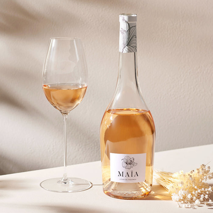 Bottle and glass of rose wine with 'Maáá' label on a neutral background