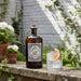 Bottle of Monkey 47 gin with a cocktail on a stone ledge outdoors