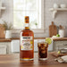 Mount Gay Spiced rum bottle with a glass of iced tea on a kitchen counter.