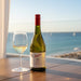 Penfolds wine bottle and glass on a table with ocean view