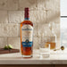 Bottle of Santa Teresa 1796 rum on a countertop with a glass and lime.