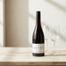 Bottle of Aotea wine with two glasses on a wooden surface