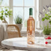 Bottle of Chateau d'Estoublon Source de Roseblood Provence Rose on a marble table with a glass and fruits in a bright room.