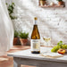 Bottle of Valpolicella wine on a table with a glass and grapes, outdoor setting