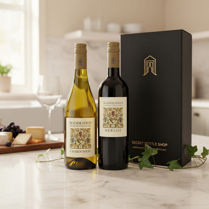 Two bottles of Waddesdon wine with a black gift box on a marble surface.