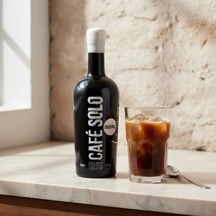Cafe Solo bottle with a glass of iced coffee on a marble surface.