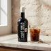 Cafe Solo bottle with a glass of iced coffee on a marble surface.