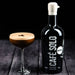 Bottle of Café Solo liqueur next to a cocktail on a dark surface