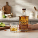 Bottle Cheers To The Best Dad Engraved Spiced Rum with 'Cheers to the Best Dad' text and a glass of whiskey on a kitchen counter.