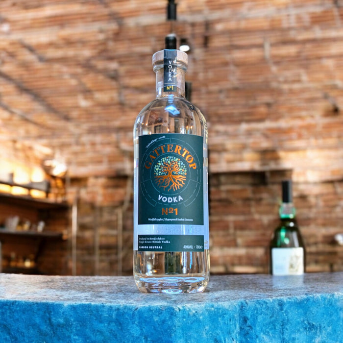 A Bottle of Gattertop vodka on a stone countertop with brick background