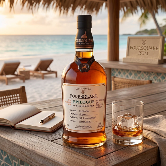 A bottle of Foursquare Epilogue single blended rum sits on a wooden table at a beachside bar, with a filled rocks glass, an open book, and lounge chairs in the background.