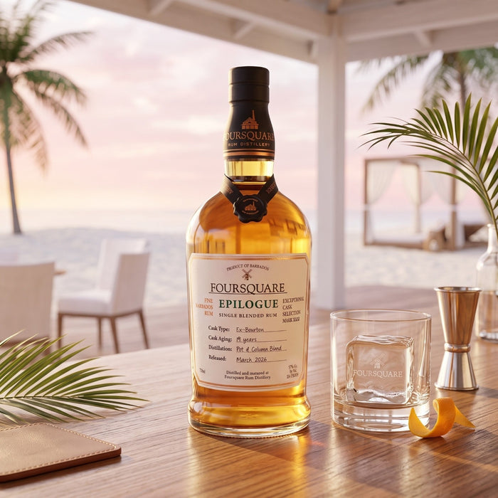 A bottle of Foursquare Epilogue Rum stands on a wooden table in a bright, airy patio setting with a beach and palm trees blurred in the background. A clear whisky glass, a metal jigger, and a lemon twist are placed beside it.