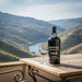 Kopke Colheita 1966 Porto bottle with a glass on a wooden table with a scenic background