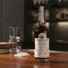 Leiper's Fork whiskey bottle on a bar with a glass and ice cubes.