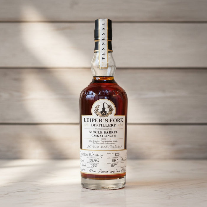Bottle of Leiper's Fork Distillery whiskey on a wooden surface with a blurred wooden background