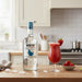 Mount Gay rum bottle with a strawberry daiquiri on a kitchen counter
